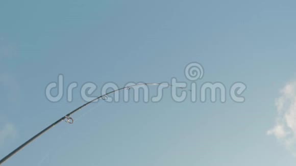 背景蓝色天空的弯曲钓竿的视图白种人渔民在捕鱼时从河里捞出鱼低视频的预览图