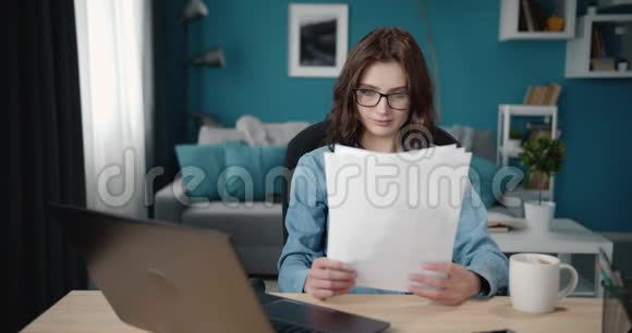 女性阅读文件和工作笔记本电脑视频的预览图