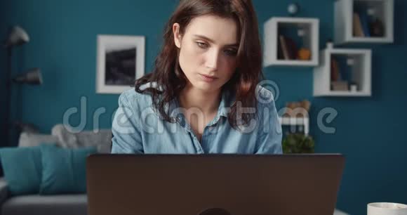 伤心的女孩在家里用电脑工作的肖像视频的预览图