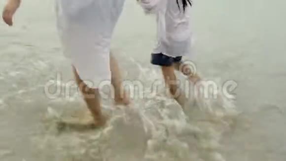 快乐的亚洲家庭妈妈和小女儿一起在夏天的海滩上散步休闲视频的预览图