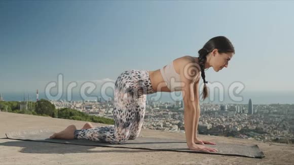 瑜伽教练在城市做猫姿势在户外练习瑜伽的妇女视频的预览图