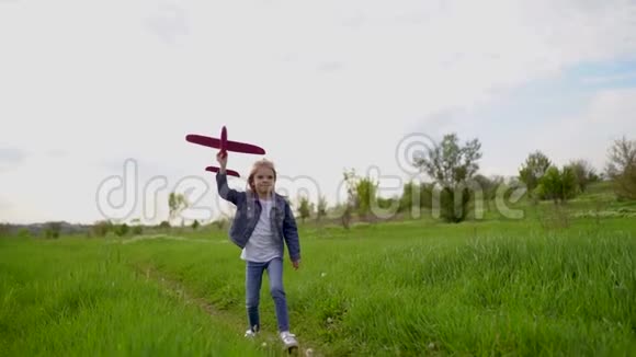 小女孩在公园户外向空中发射一架玩具飞机幼儿推出玩具飞机漂亮的小姑娘视频的预览图