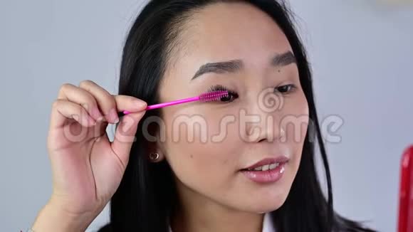 亚洲人用刷子刷她的延伸睫毛女人的眼皮化妆睫毛膏美容业视频的预览图