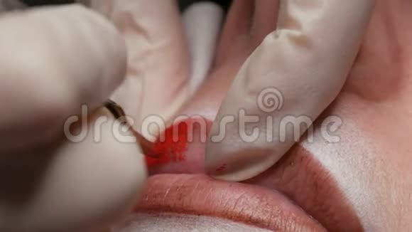 永久化妆嘴唇程序双手戴乳胶手套一位熟练的美容师用颜料化妆嘴唇视频的预览图