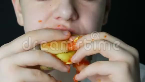 一个十几岁的男孩的嘴他吃了一个多汁的汉堡一个芝士汉堡或汉堡里面有奶酪肉切片和泡菜视频的预览图