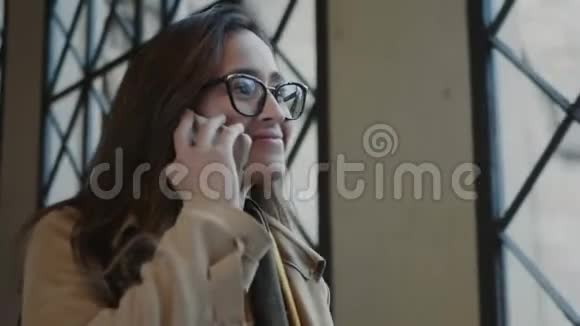 学生在大学里用手机说话打电话给智能手机的女商人视频的预览图