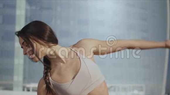 女人在街上做反向战士瑜伽姿势女士在户外活动视频的预览图