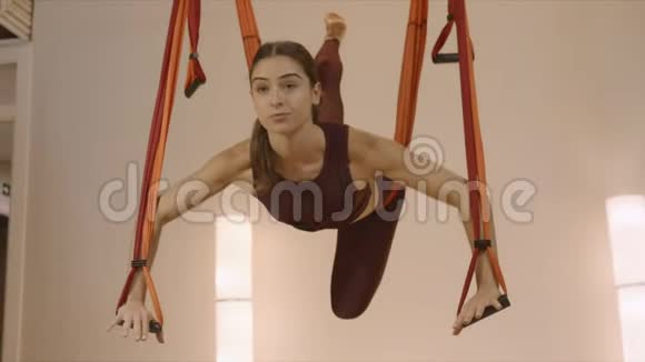 运动的女人在工作室练习飞行瑜伽在演播室换姿势的女孩视频的预览图