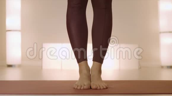 赤脚的女人在课堂上站在垫子上做树姿的女人腿视频的预览图