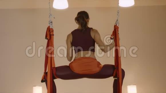 瑜伽教练在吊床上做倒立女子空中瑜伽视频的预览图