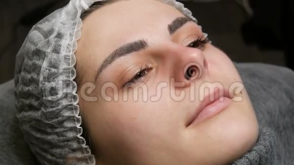 永久性唇妆的准备一个戴着特殊帽子的年轻女孩的脸而不是纹身的嘴唇视频的预览图