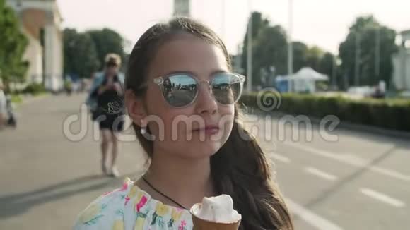 在游乐园散步的轻松女孩少女在吃冰淇淋视频的预览图