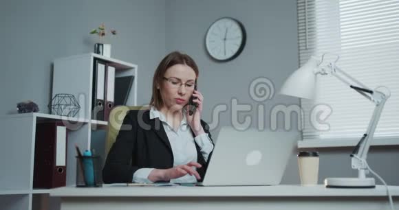 办公室工作人员在办公桌前用手机拨打客户电话和交谈视频的预览图