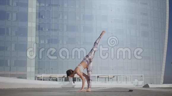 女人向下面对狗姿势街头女孩做瑜伽练习视频的预览图