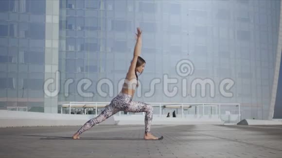 站在街边的女战士摆姿势城市街头练习瑜伽的女孩视频的预览图