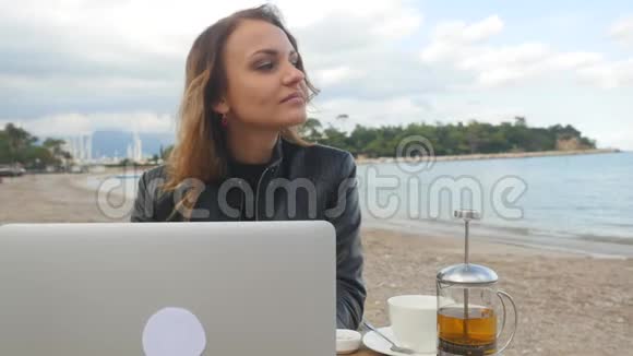 在户外使用笔记本电脑的年轻女性视频的预览图
