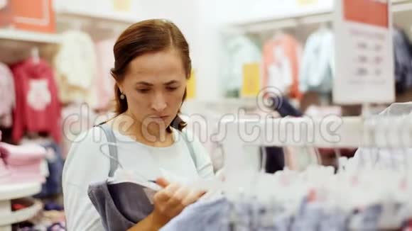 商店里的女人为她的女儿挑选一件衣服视频的预览图