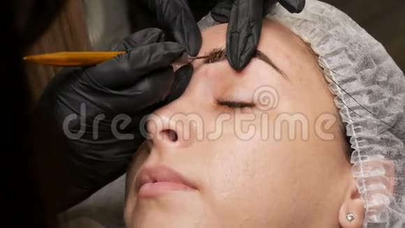 手工微提技术大师用特殊笔涂上特殊的深色颜料染眉毛视频的预览图
