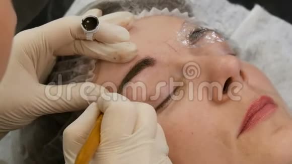 手工微提技术大师用特殊笔涂上特殊的深色颜料染眉毛视频的预览图