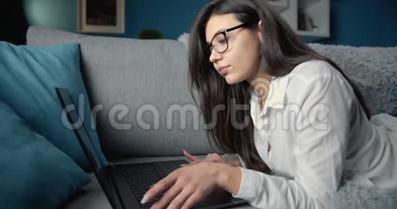 在笔记本电脑上工作的严肃妇女的侧视视频的预览图