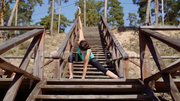 大自然中的女孩站在斜坡上做身体伸展身体的灵活性视频的预览图