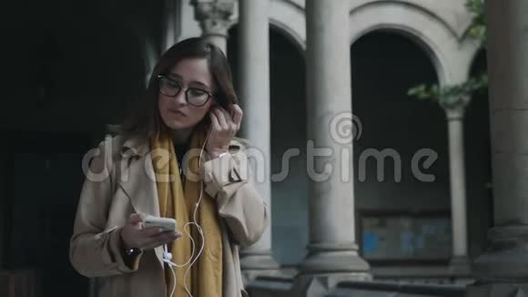 女人戴上耳机女商人在户外听耳塞音乐视频的预览图