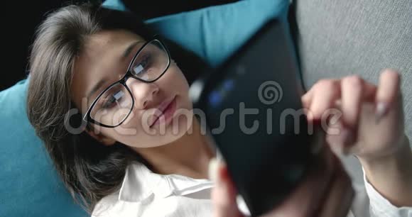 带智能手机屏幕反光眼镜的女性视频的预览图
