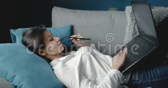 可爱的女士在笔记本电脑上浏览互联网视频的预览图