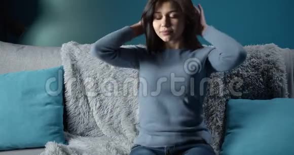 可爱的黑发女孩在沙发上放松视频的预览图