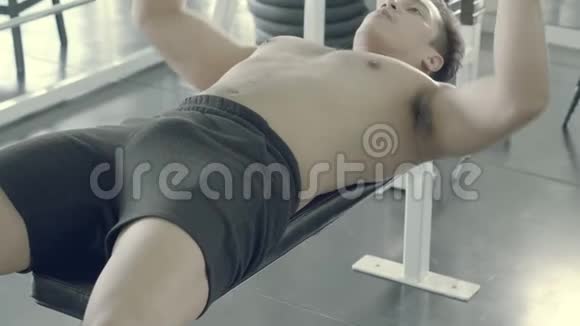 年轻的亚洲男子做胸外按压以锻炼身体在健身房精疲力竭亚洲男子努力锻炼和运动训练视频的预览图