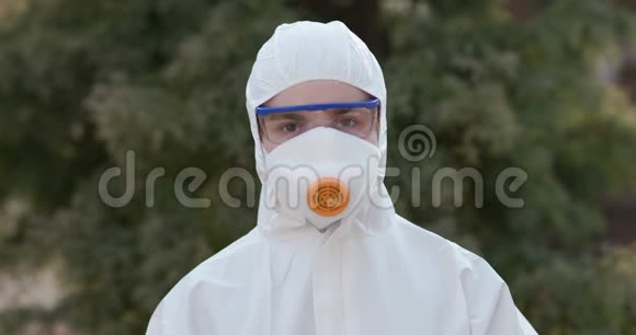 特写病毒学家穿着防护服护目镜和呼吸器的肖像Codid19冠状病毒流行视频的预览图