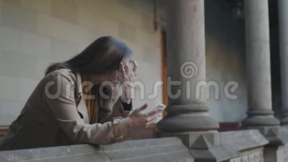 学生在电话里读坏消息在户外使用智能手机的女商人视频的预览图