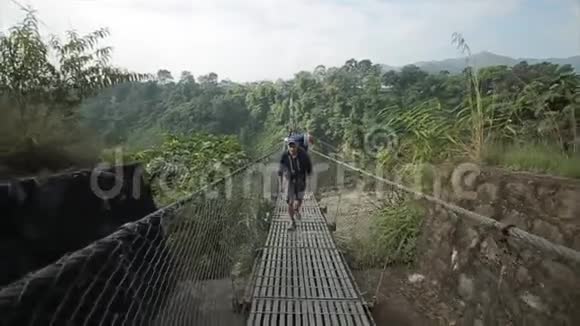 一个背包客在尼泊尔过桥森林探险高山森林视频的预览图
