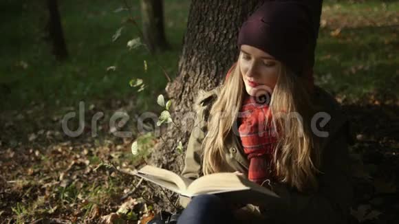 开朗的年轻白种人女孩在秋天在公园看书视频的预览图