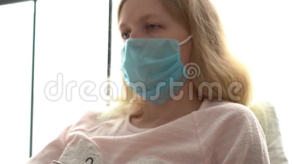 冠状病毒流行的检疫一个被感染的蒙面妇女正在卧室的床上休息视频的预览图