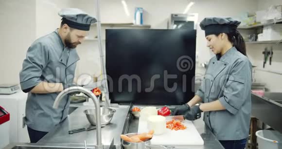 两个同事一起在专业厨房做饭视频的预览图