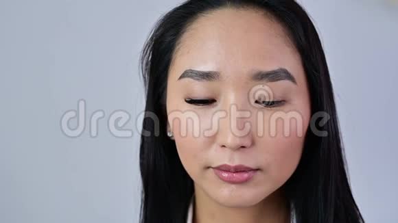 长睫毛的亚洲人睁开了眼睛前人工睫毛与双卷在一只眼睛视频的预览图