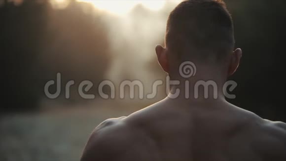 跑步运动员适合肌肉发达的年轻男性跑步者赤裸的躯干在黎明日出前冲刺树木慢慢视频的预览图