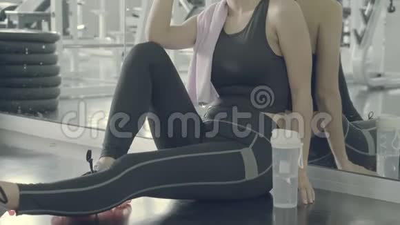 美丽的年轻亚洲女人在健身房锻炼后疲惫而疲惫视频的预览图