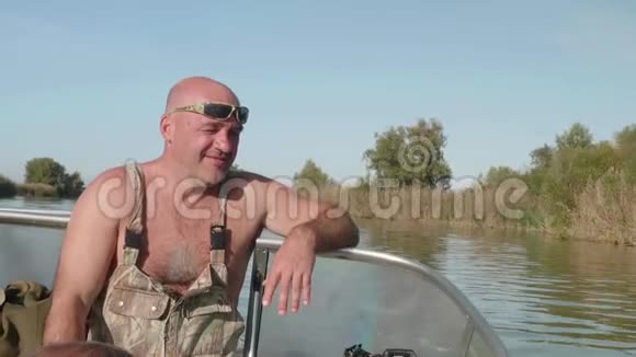 白人渔夫坐在那里微笑初晴的秋晨在河上男人休闲和放松前景视频的预览图