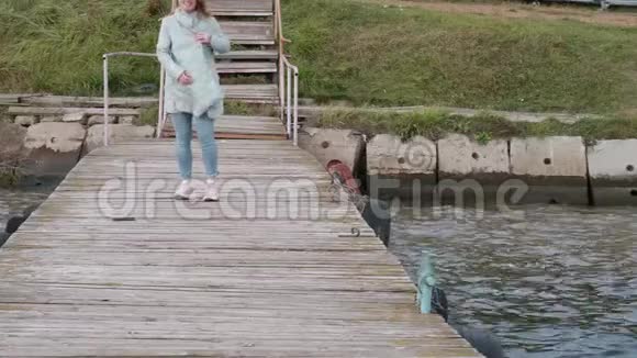 穿着蓝色外套和粉红色运动鞋的女人笑着朝镜头跑去视频的预览图