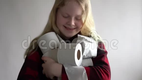 有趣的视频由于冠状病毒的流行而被隔离戴面具的女孩拿着一卷装在灰色的卫生纸视频的预览图