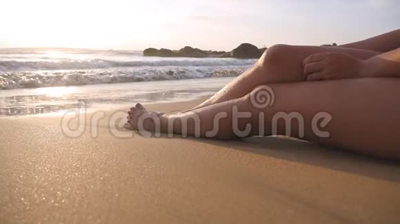 美丽的年轻女子躺在沙滩上的金色沙滩上在暑假旅行中放松性感女孩坐在视频的预览图