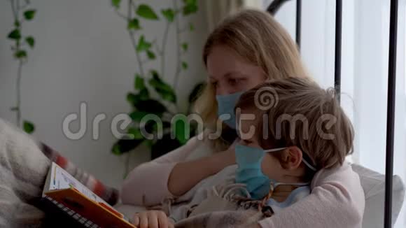 冠状病毒流行的检疫受感染的蒙面母亲和小儿子正在卧室的床上休息视频的预览图