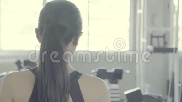 美丽的年轻亚洲女子步行去模拟器锻炼与伸展腿在健身房视频的预览图