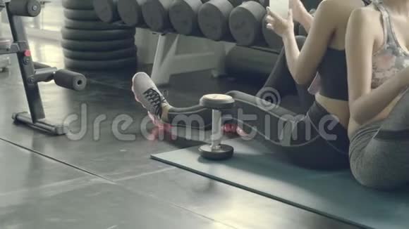 美丽的亚洲年轻女性在健身房锻炼后用新鲜的饮料放松饮用水亚洲女孩休息锻炼运动训练视频的预览图