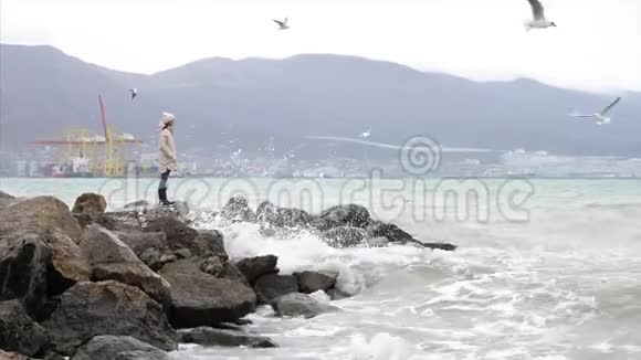 在刮风的天气里女人在空海边散步海浪拍打着视频的预览图