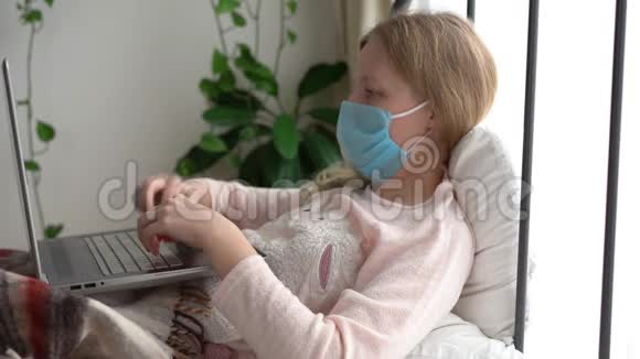 冠状病毒流行的检疫一个被感染的蒙面妇女在家里用笔记本电脑工作视频的预览图