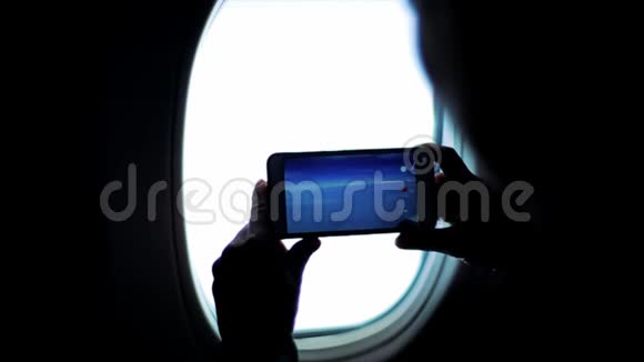 从飞机窗口拍摄山和云的人的剪影视频的预览图