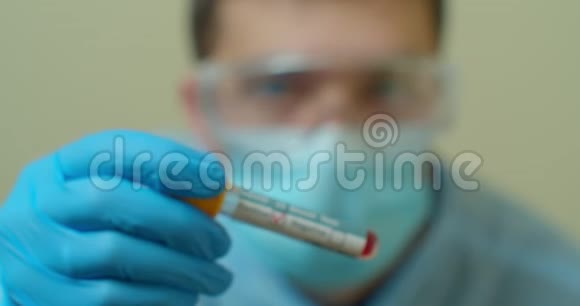合格的医务工作者穿着保护制服用血液拿着试管对COVID19病毒进行分析概念视频的预览图